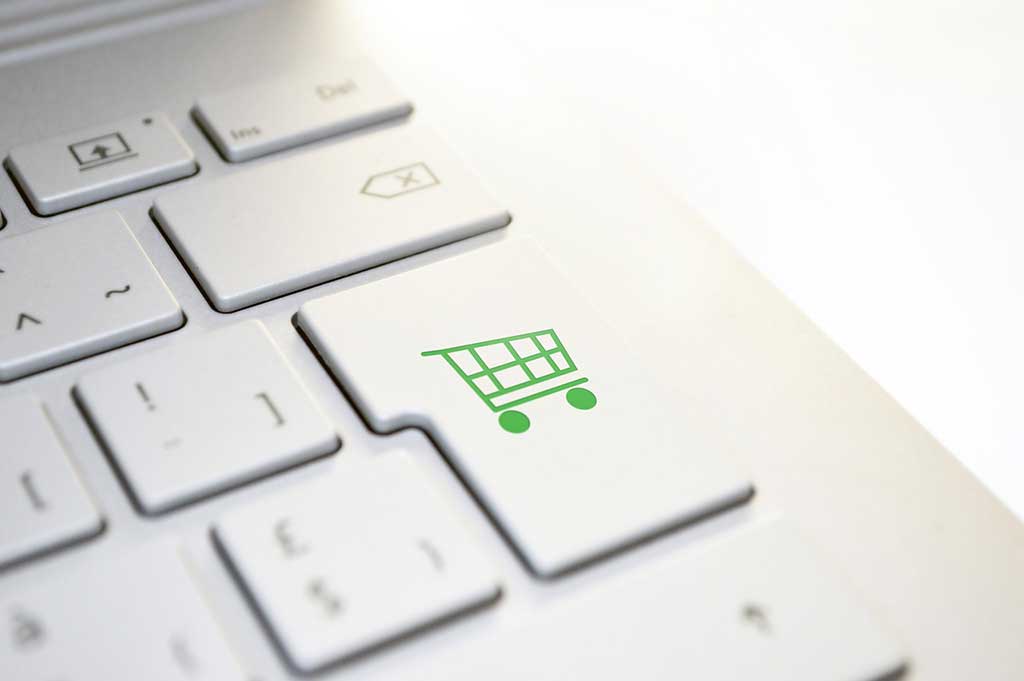 comportamiento del consumidor online ilustrado por un teclado con la tecla carrito de compra