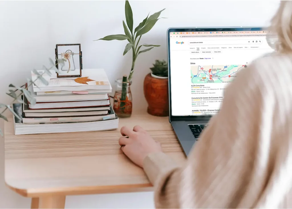 SEO para pymes mujer en el ordenador. En la pantalla se ve el motor de busqueda de google con una busqueda local.